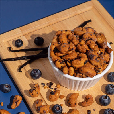 Bowl of blueberry vanilla cashews with fresh blueberries and vanilla pods