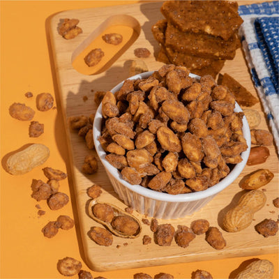 Bowl of butter toffee peanuts on a wooden board