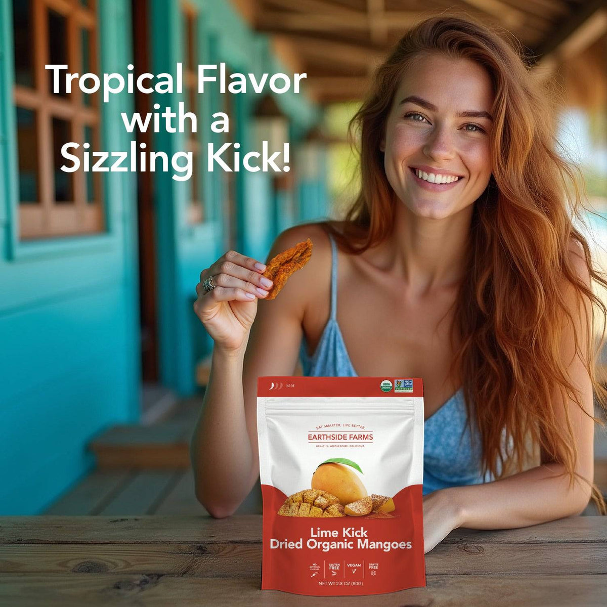 Smiling woman eating Lime Kick chili lime dried mango at a table